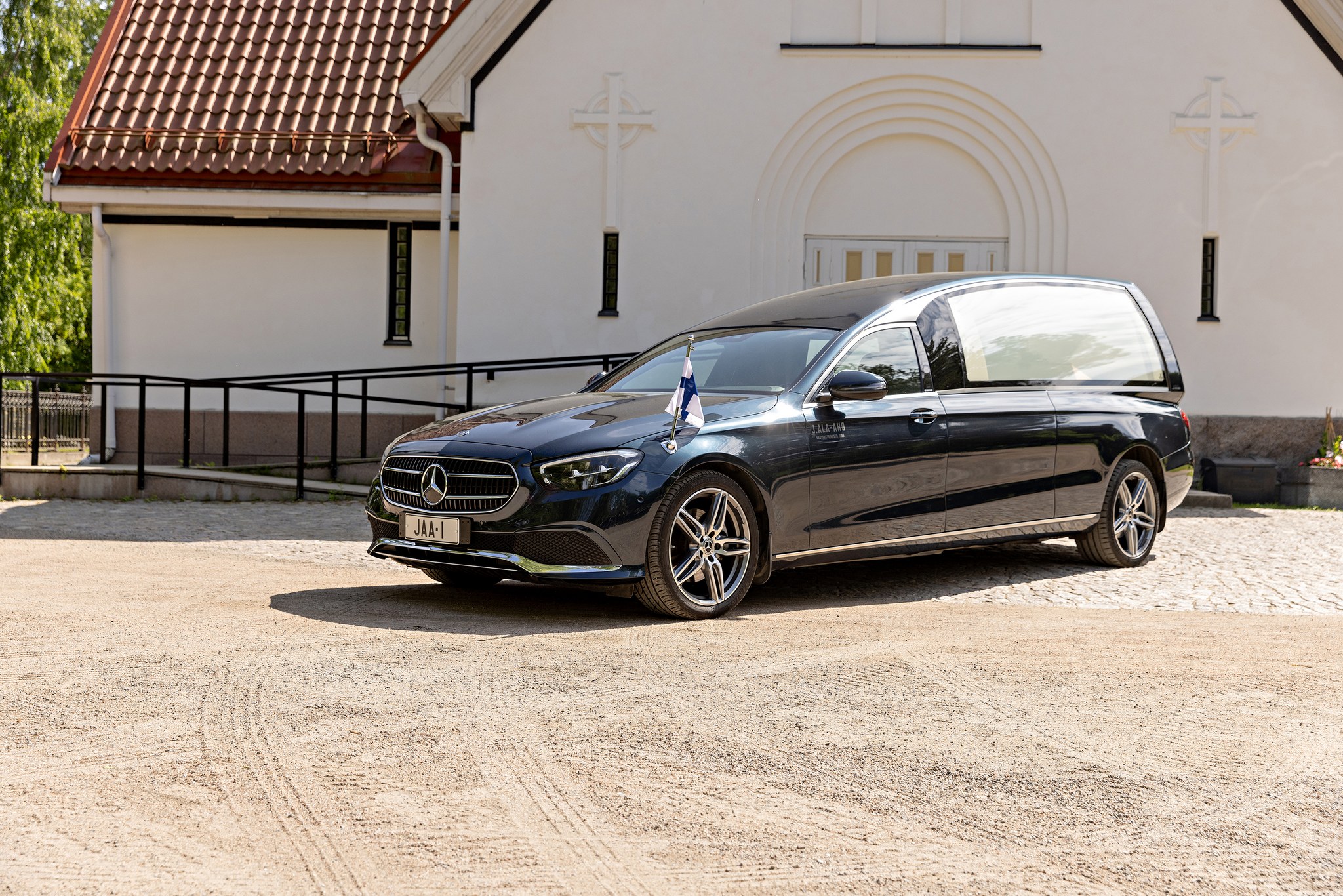 J. Ala-Ahon Hautaustoimiston Mercedes-Benz-hautausauto kappelin edessä.